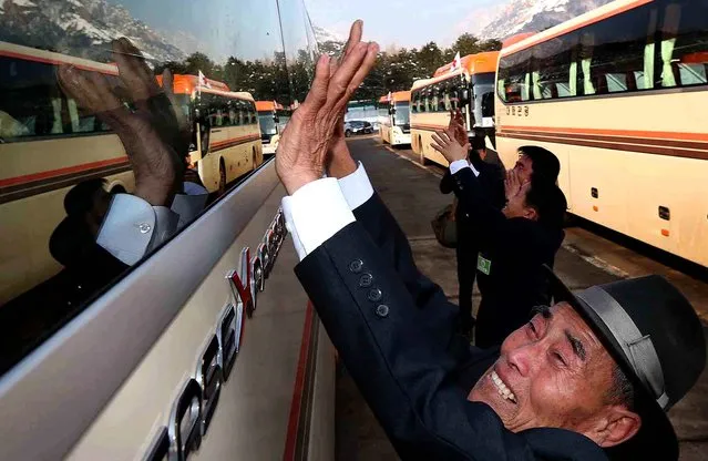 Park Woon Hyung, 93, of North Korea, waves to his South Korean relatives in a bus before it leaves for South Korea, after a separated family reunion meeting at the Diamond Mountain resort in North Korea, on February 22, 2014. Elderly North and South Koreans separated for six decades were tearfully reuniting, grateful to embrace children, brothers, sisters and spouses they had thought they might never see again.  (Photo by Lee Ji-eun/Yonhap)