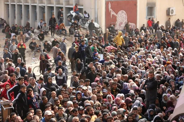 Palestinians gather in front of UN agency for Palestinian refugees (UNRWA) building to receive the 5 kg flour aid as the first humanitarian aid convoy in months has entered Gaza amid Israeli attacks in Jabalia, Gaza on March 17, 2024. (Photo by Dawoud Abo Alkas/Anadolu via Getty Images)