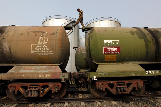 A worker walks atop a tanker wagon to check the freight level at an oil terminal on the outskirts of Kolkata, India in this November 27, 2013 file photo. (Photo by Rupak De Chowdhuri/Reuters)