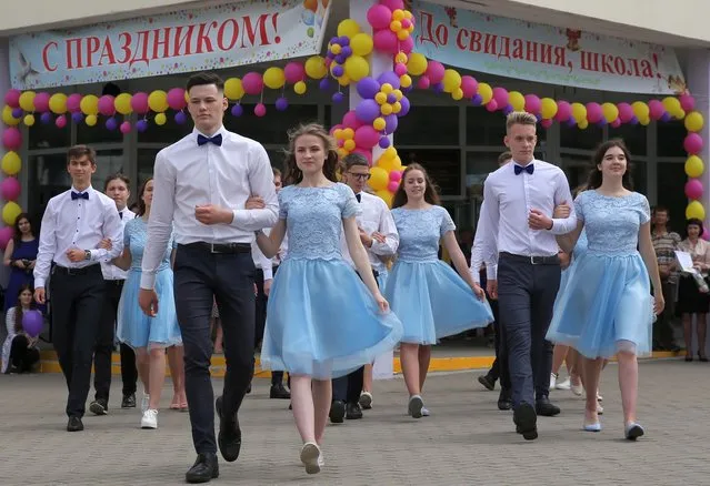 Future high school graduates dance during the “Last Bell” holiday, a traditional ceremony carried out just after all the studies are finished, but before the final exams, at their school in Minsk, Belarus, 29 May 2019. More than 55 thousands of young people celebrate the last day in school on 29 and 30 May in Belarus, local media report. The banners read: “Congratulations! Good bye, school!”. (Photo by Tatyana Zenkovich/EPA/EFE)