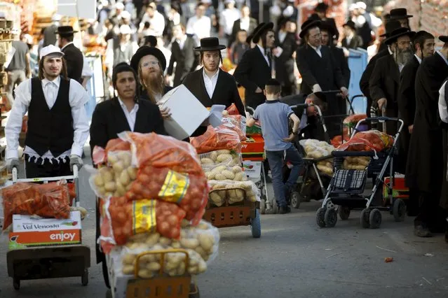 Ultra-Orthodox Jewish men carry bags of food during a distribution of food for families for the upcoming Jewish holiday of Passover near Jerusalem's Mea Shearim neighbourhood April 19, 2016. (Photo by Ronen Zvulun/Reuters)