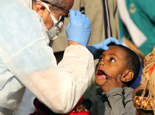A doctor examines a child after he disembarked from the German Navy ship Schleswig Holstein at the Reggio Calabria harbor, Italy, Tuesday, June 16, 2015. European Union nations failed to bridge differences Tuesday over an emergency plan to share the burden of the thousands of refugees crossing the Mediterranean, while on the French-Italian border, police in riot gear forcibly removed dozens of migrants. (AP Photo/Adriana Sapone) 