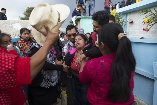 People help Gloria Perez as she begins to faint during the burial of 14-year-old Ana Roselia Perez Junay who died in a fire at a children's shelter, at the cemetery in Zaragoza, Guatemala, Sunday, March 12, 2017. The death toll in the March 8 fire rose to 40 on Sunday with the announcement that another girl has died of burns. (Photo by Moises Castillo/AP Photo)
