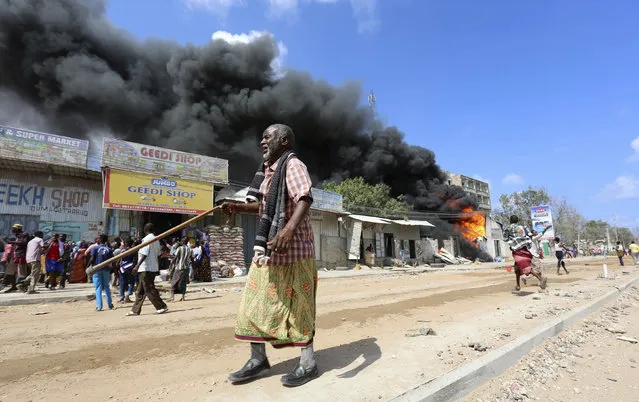 Somali traders attempt to evacuate their goods from their shops near a burning petrol station in Hodan district of Somalia's capital Mogadishu, April 10, 2014. (Photo by Feisal Omar/Reuters)