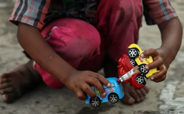 A child of a farmer from the drought affected districts of Maharashtra plays with the toy car at a temperory refugee camp in Mumbai, India, 26 April 2016. According to reports, 21 districts in Maharashtra are drought-affected. Hundreds of people are staying in a refugee camp in Mumbai, migrated from the drought affected area in Maharashtra. (Photo by Divyakant Solanki/EPA)