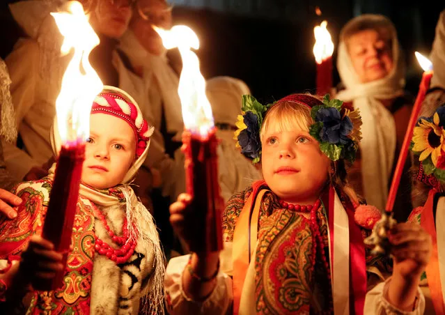 Children dressed in traditional Ukrainian outfits hold candles during the “holy fire” ceremony on the eve of the Orthodox Easter service, outside the Volodymysky Cathedral in Kiev, Ukraine, April 30, 2016. (Photo by Valentyn Ogirenko/Reuters)