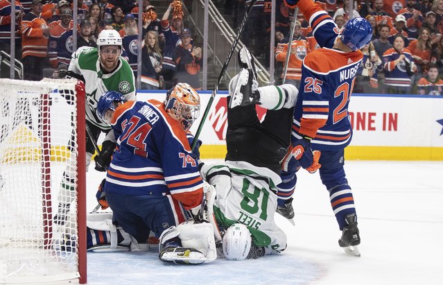 Dallas Stars' Sam Steel (18) is upended in front of the net as Edmonton Oilers goalie Stuart Skinner (74) makes a save during the third period of Game 4 of the Western Conference final in the NHL hockey Stanley Cup playoffs, Wednesday, May 29, 2024, in Edmonton, Alberta. (Photo by Jason Franson/The Canadian Press via AP Photo)