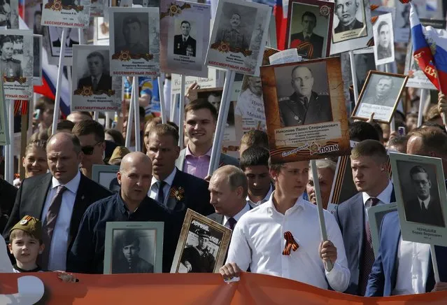 Russian President Vladimir Putin (C) holds the portrait of his father, war veteran Vladimir Spiridonovich Putin as he takes part in the Immortal Regiment march during the Victory Day celebrations, marking the 71st anniversary of the victory over Nazi Germany in World War Two, at Red Square in Moscow, Russia, May 9, 2016. (Photo by Sergei Karpukhin/Reuters)