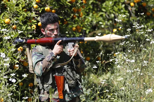 A Hezbollah fighter holds an RPG as he takes his position between orange trees, at the coastal border town of Naqoura, south Lebanon, Thursday, April 20, 2017. Hezbollah organized a media tour along the border with Israel meant to provide an insight into defensive measures established by the Israeli forces along the southern frontier in the past year in preparation for any future conflict. (Photo by Hussein Malla/AP Photo)