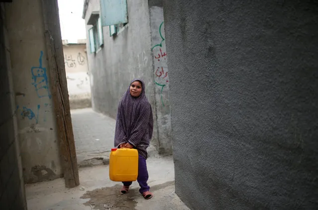 A Palestinian girl carries a potable water container after filling it from a public tap in Jabaliya refugee camp in the northern Gaza Strip January 24, 2017. (Photo by Mohammed Salem/Reuters)