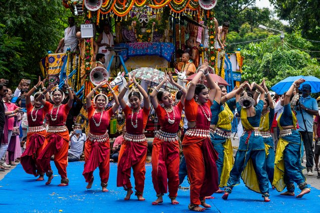 Artists perform in front of the chariot of Hindu god Jagannath during the return of the chariots festival in Kolkata, India, Monday, July 15, 2024. The return of the chariots marks the end of the nine-day long chariot festival. (Photo by Bikas Das/AP Photo)