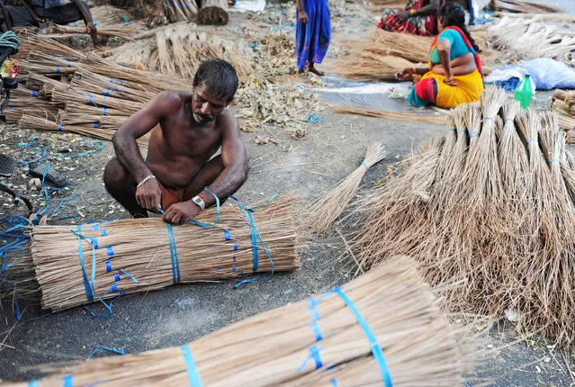 Indian labourer Krishnan, 41, bundles finished coconut leaves used to make broom sticks  at a production unit in Chennai on May 31, 2016. India's economy grew 7.6 percent in 2015-16, official figures showed May 31, retaining its place as the world's fastest-growing major economy and providing a boost to the right-wing government as it marks two years in power. Gross domestic product (GDP) expanded at a faster pace in the fourth quarter of the financial year, growing 7.9 percent year-on-year, the Central Statistics Office data showed. (Photo by Arun Sankar/AFP Photo)