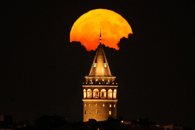 A full moon rises behind Galata Tower landmark in Istanbul, Turkey, Sunday, July 21, 2024. (Photo by Emrah Gurel/AP Photo)