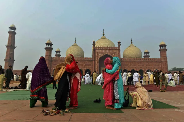 Pakistani Muslim devotees hug each other to celebrate Eid after offering the Eid al-Adha prayers at the Badshahi Mosque in Lahore on October 6, 2014. Muslims across the world are celebrating the annual festival of Eid al-Adha, or the Festival of Sacrifice, which marks the end of the Hajj pilgrimage to Mecca and commemorates Prophet Abraham's readiness to sacrifice his son to show obedience to God. (Photo by Arif Ali/AFP Photo)