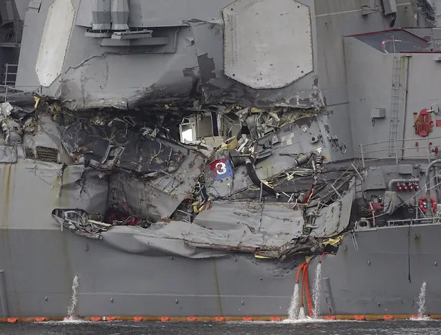Damaged part of USS Fitzgerald is seen at the U.S. Naval base in Yokosuka, southwest of Tokyo Sunday, June 18, 2017. Navy divers found a number of sailors' bodies Sunday aboard the stricken USS Fitzgerald that collided with a container ship Saturday in the busy sea off Japan. (Photo by Eugene Hoshiko/AP Photo)