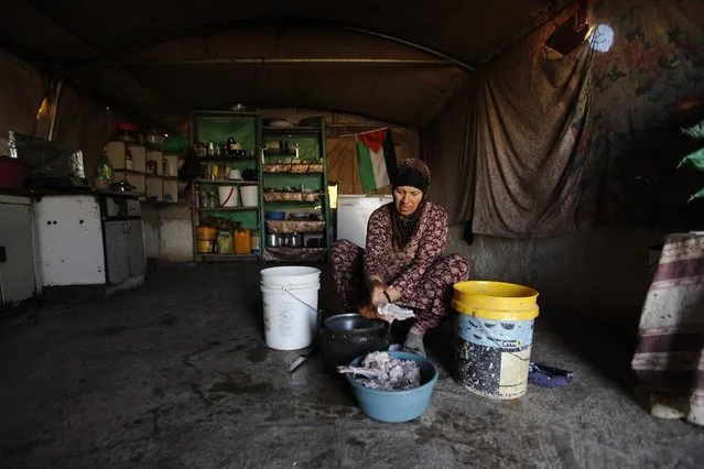 In this Tuesday, July 21, 2015, photo, a Palestinian woman cooks in her family tent in the village of Susiya, south of the West Bank city of Hebron. (Photo by Majdi Mohammed/AP Photo)