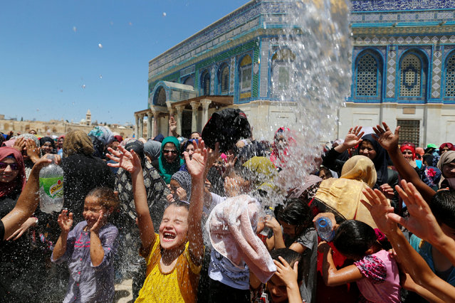 Palestinian men spray water on children to cool them down before prayers on the third Friday of the holy month of Ramadan near the Dome of the Rock, on the compound known to Muslims as Noble Sanctuary and to Jews as Temple Mount, in Jerusalem's Old City, June 24, 2016. (Photo by Ammar Awad/Reuters)