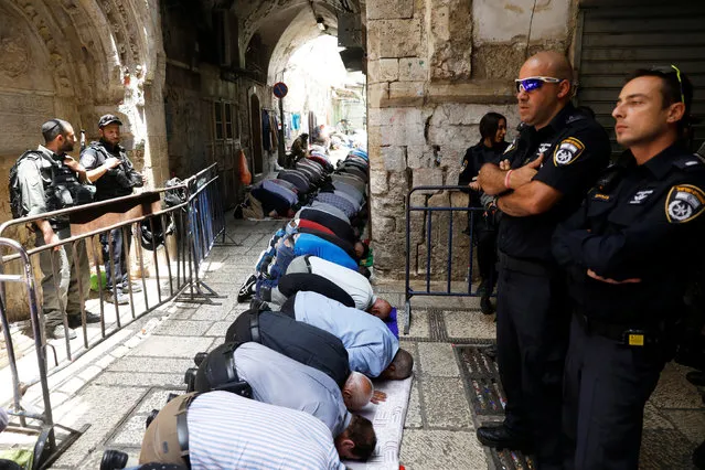 Palestinian men pray as Israeli security forces secure outside the compound known to Muslims as Noble Sanctuary and to Jews as Temple Mount, in Jerusalem's Old City July 26, 2017. (Photo by Ronen Zvulun/Reuters)