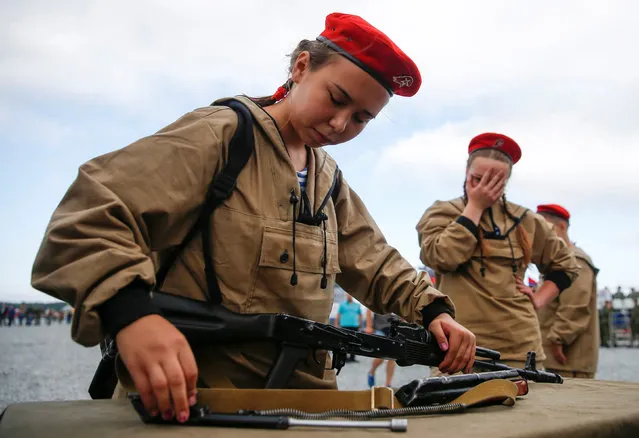 A girl assembles an AK-74 before the Safe Route competition at the International Army Games 2017 at the Andreyevsky military polygon outside Tyumen, Russia, August 6, 2017. (Photo by Maxim Shemetov/Reuters)