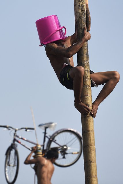 Men attempt to climb a greased pole to retrieve prizes at the top during celebrations to mark Indonesia's 70th independence anniversary in Jakarta, Indonesia August 17, 2015 in this photo taken by Antara Foto. (Photo by Sigid Kurniawan/Reuters/Antara Foto)