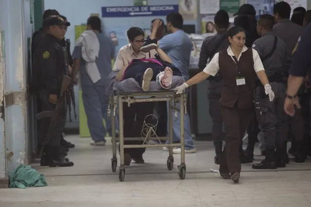 Nurses transport Astrid Villatoro who was wounded by a stray bullet during an assault staged by unknown attackers at the Roosevelt Hospital, in Guatemala City, Wednesday, August 16, 2017.  Gunmen stormed the Roosevelt, one of Guatemala's largest hospitals, and opened fire early Wednesday in an assault staged to free an imprisoned gang member, officials said. Villatoro was at the hospital waiting for her son to get an X-ray when the gunfire broke out. At least seven people were killed and five were arrested. (Photo by Luis Soto/AP Photo)