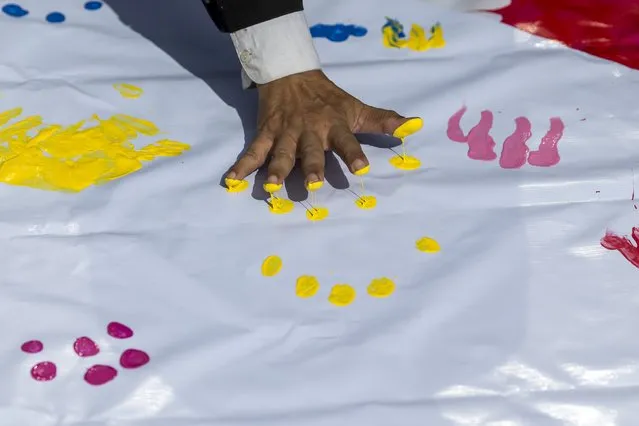 A man leaves finger prints on a banner for the victims killed in Monday's bomb blast during a religious ceremony near at the Erawan shrine, the site of Monday's deadly blast, in central Bangkok, Thailand, August 21, 2015. (Photo by Athit Perawongmetha/Reuters)