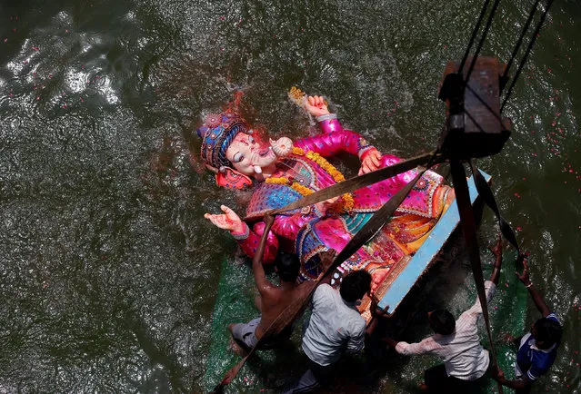 Devotees immerse an idol of the Hindu god Ganesh, the deity of prosperity, into the Sabarmati river on the last day of the Ganesh Chaturthi festival in Ahmedabad, India September 5, 2017. (Photo by Amit Dave/Reuters)