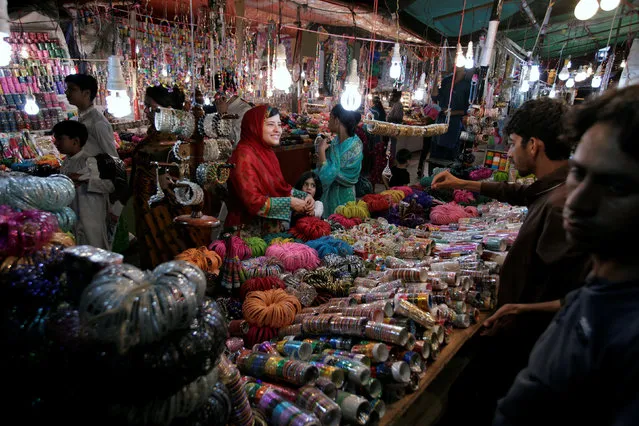 A woman buy bangles and jewellery at a stall ahead of Eid al-Fitr in Islamabad, Pakistan, July 4, 2016. (Photo by Faisal Mahmood/Reuters)