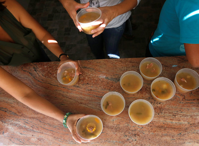 Teachers prepare soup for the students during an activity for the end of the school year at the Padre Jose Maria Velaz school in Caracas, Venezuela July 12, 2016. (Photo by Carlos Jasso/Reuters)