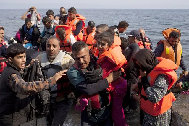 Syrian refugees jump off a dinghy as they arrive on the Greek island of Lesbos September 3, 2015. The International Organization for Migration (IOM) says 1,500-2,000 are taking the route through Greece, Macedonia and Serbia to Hungary every day and that there is “a real possibility” the flow could rise to 3,000 daily. (Photo by Dimitris Michalakis/Reuters)