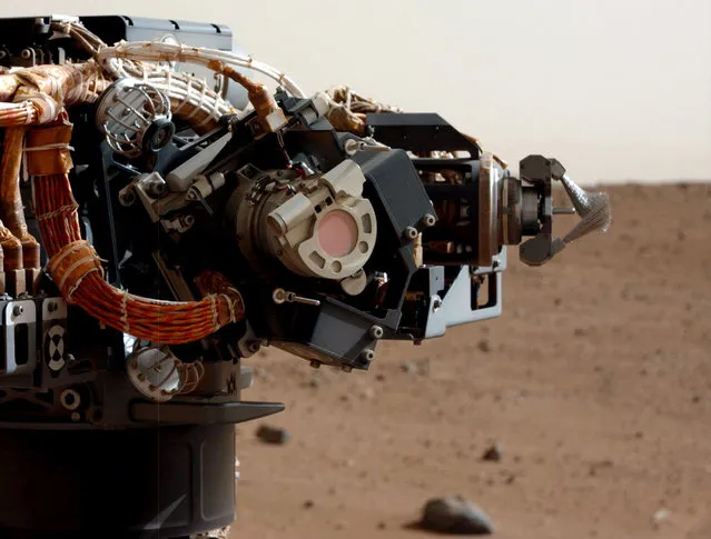 The left eye of the Mast Camera (Mastcam) on NASA's Mars rover Curiosity took this image of the MAHLI camera on the rover's arm, on Mars, on September 5, 2012. The image shows that MAHLI has a thin film or coating of Martian dust on it. This dust accumulated during Curiosity's final descent to the Martian surface, as the Mars Science Laboratory spacecraft's descent stage (or sky crane) engines were disrupting the surface nearby. The reddish circle near the center of the Mastcam Sol 30 image is the window of MAHLI's dust cover, with a diameter a little less than a soda can's diameter. The mechanism at the right in this image is Curiosity's dust removal tool, a motorized wire brush. (Photo by NASA/JPL-Caltech/MSSS)