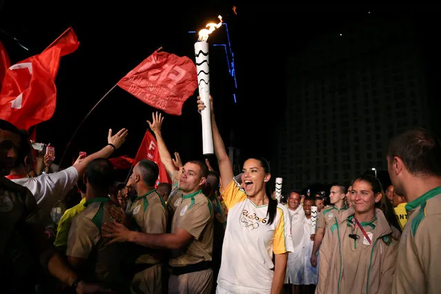 Model Adriana Lima carries the Olympic torch in Maua Square in Rio de Janeiro, Brazil, August 4, 2016. (Photo by Pilar Olivares/Reuters)