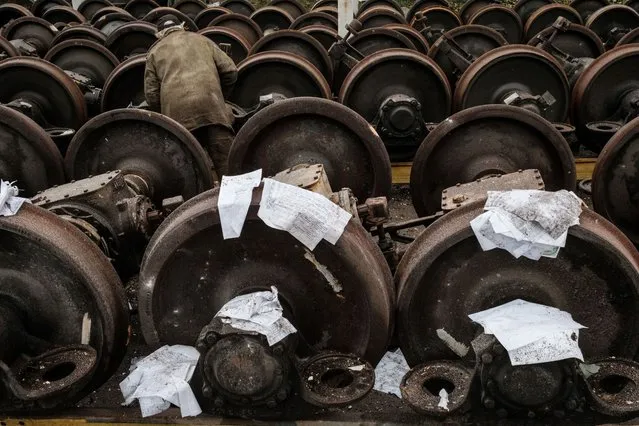 Wet documents are put on train wheels to dry near a railway yard of the freight railway station in Kharkiv, which was partially destroyed by a missile strike, amid the Russian invasion of Ukraine on September 28, 2022. Russia fired a salvo of missiles at Kharkiv overnight, officials said on, hitting a railway yard and knocking out power to more than 18,000 households in Ukraine's second city. (Photo by Yasuyoshi Chiba/AFP Photo)