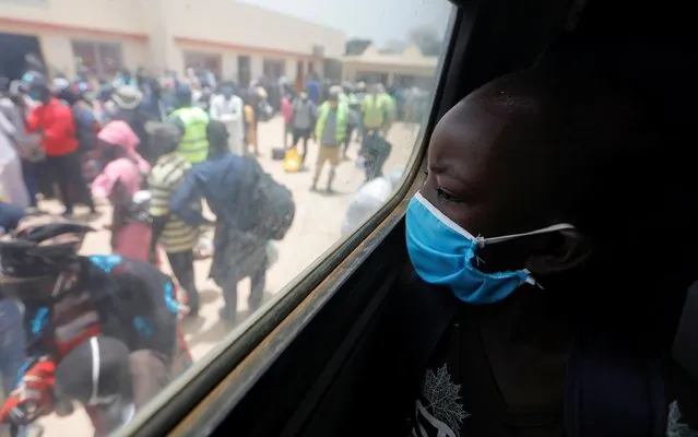 A boy looks out of a bus window as teachers prepare to board government chartered buses to go back to schools of countryside towns, scheduled to reopen next week, amid travel bans between regions due to the coronavirus disease (COVID-19) outbreak, in Dakar, Senegal on May 27, 2020. (Photo by Zohra Bensemra/Reuters)