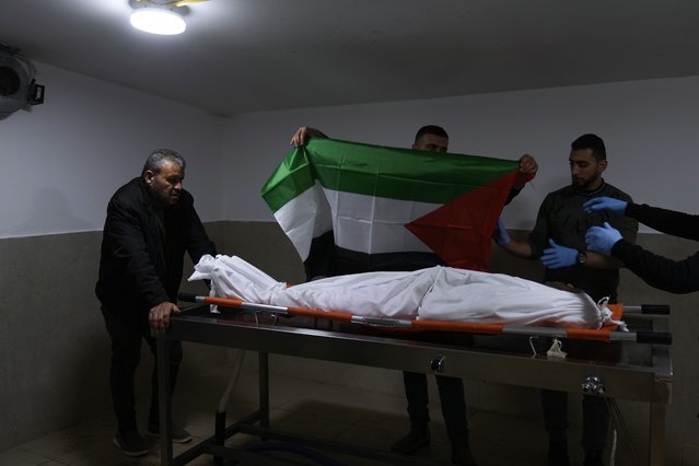 Relatives cover the body of Khalil Al-Saadi, 35, with the Palestinian flag before his funeral, almost two weeks after he was killed in an Israeli army raid, in the hospital morgue in Jenin, West Bank, Sunday, February 2, 2025. (Photo by Majdi Mohammed/AP Photo)