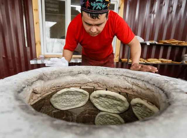 A worker looks at bread baking inside a tandoor clay oven in a bakery in the village of Guldala near Almaty, Kazakhstan on November 3, 2017. (Photo by Shamil Zhumatov/Reuters)