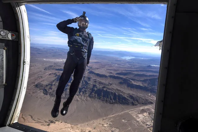 A member of the Air Force's Wings of Blue Parachute Demonstration Team salutes as he jumps out of an aircraft, during the opening ceremony of Aviation Nation 2017 Nellis Air and Space Expo at Nellis Air Force Base, Nev., November 10, 2017. (Photo by Senior Airman Kevin Tanenbaum/Reuters/U.S. Air Force)