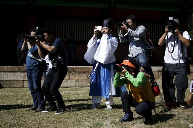 A man (C) dressed in traditional costume takes photographs among photographers during the grand Confucian ceremony of Seokjeon at a shrine at Sungkyunkwan University in Seoul, South Korea, September 18, 2015. (Photo by Kim Hong-Ji/Reuters)