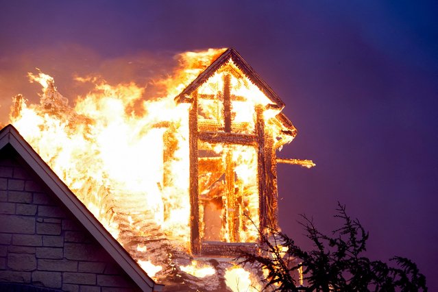 A residence burns during a wildfire outbreak in Stillwater, Oklahoma, on March 14, 2025. (Photo by Nick Oxford/Reuters)
