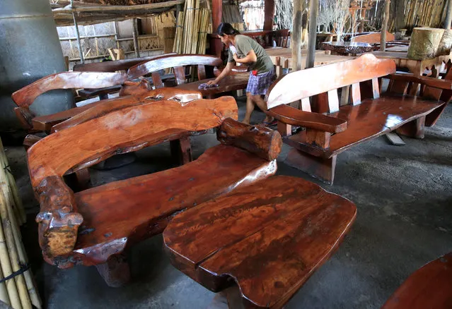 Worker Amy Lizen, 44, uses a wet cloth to clean their export furniture made of acacia and mahogany wood inside a shop in Cavite city, south of Manila, Philippines July 12, 2016. (Photo by Romeo Ranoco/Reuters)