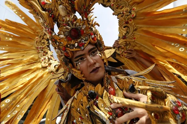 An Indonesian model wearing a colorful costume participates in a parade during the Batam Island International Culture Festival in Batam Island, Indonesia, 16 December 2017. Batam Island, an industrial area in Indonesia, is boosting the tourism sector to improve the economy of its community by eyeing the visitors' boom of next door country Singapore. (Photo by Hotli Simanjuntak/EPA/EFE)