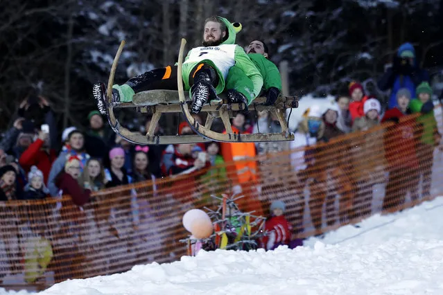 Men soar through the air on their wooden sledge during a traditional Bavarian horn sledge race, known as “Schnablerrennen” in Gaissach near Bad Toelz, Germany on January 22, 2017. The race is held annually on sledges with long horn-shaped runners, which were formerly used to bring hay or logs down from the mountains. (Photo by Matthias Schrader/AP Photo)