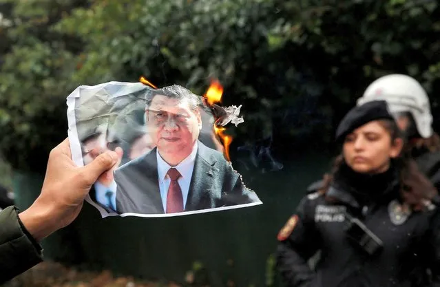 An ethnic Uyghur demonstrator burns a portrait of Chinese President Xi Jinping during a protest against China, in front of the Chinese consulate in Istanbul, Turkey on November 30, 2022. (Photo by Dilara Senkaya/Reuters)