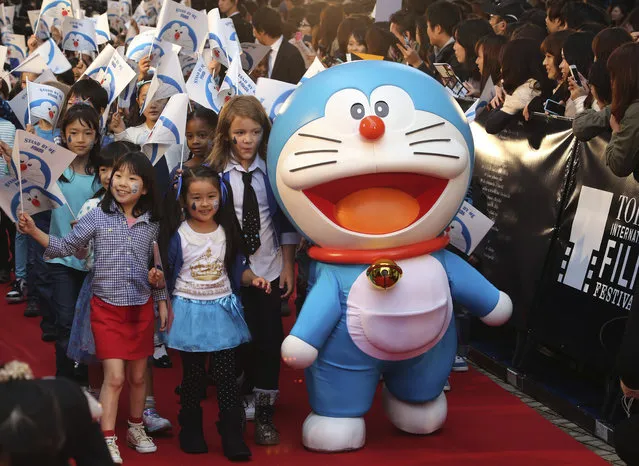 Japan's popular animation character Doraemon walks on the red carpet with children during the opening ceremony of the 27th Tokyo International Film Festival in Tokyo, Thursday, October 23, 2014. (Photo by Koji Sasahara/AP Photo)