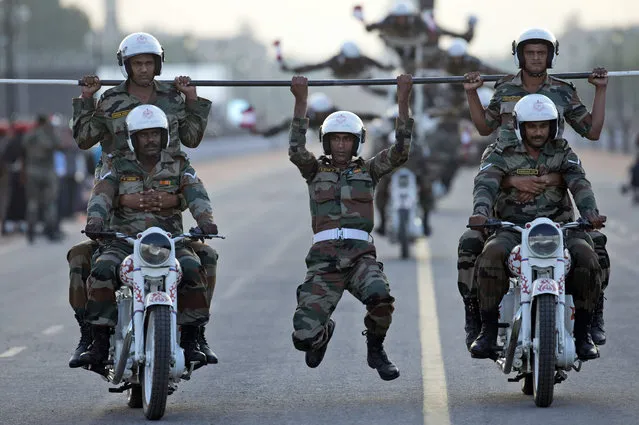 Indian army soldiers perform a daredevil motorcycle stunt during a parade to mark the 50th anniversary of the India-Pakistan war of 1965, in New Delhi, India, Sunday, September 20, 2015. The parade concluded celebrations to honor soldiers who fought the war in 1965. (Photo by Tsering Topgyal/AP Photo)