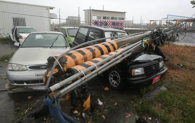 Vehicles are crushed by broken electric line poles in typhoon-hit Taiwan, southeast China, September 14, 2016. Typhoon Meranti on Wednesday brought strong winds and heavy downpour to the island. (Photo by Xinhua/Barcroft Images)