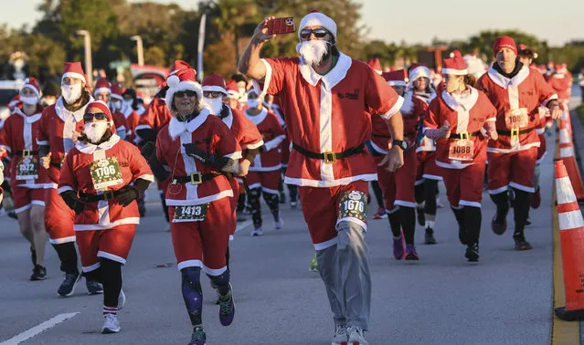 More than 800 runners dressed as Santa Claus braved near freezing temperatures to participate in the Run Run Santa 1 Mile Saturday December 24, 2022 in Viera, Fla. The temperatures were in the low 30's and the coldest in the race's 7-year history. (Photo by Craig Bailey /Florida Today via AP Photo)
