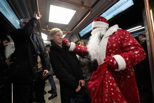 Employees of Moscow Metro dressed as Father Frosts take part in a Christmas and New Year flash mob for passengers in the Moscow underground on December 30, 2022. (Photo by Natalia Kolesnikova/AFP Photo)