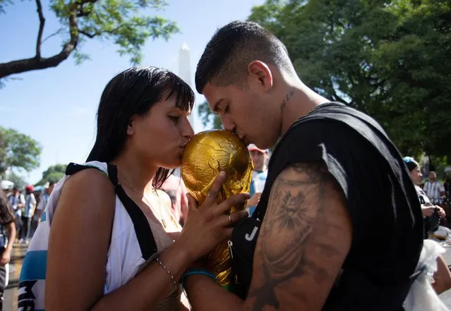 Argentina fans kiss a replica World Cup trophy after the victory parade was cancelled and Argentina players departed in Buenos Aires on December 20, 2022. (Photo by Gonzalo Colini/Reuters)