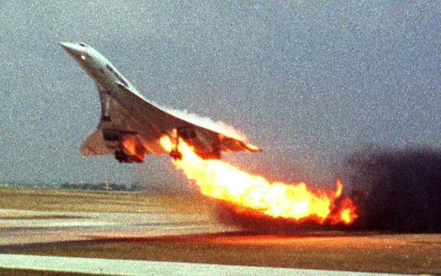 Air France Concorde flight 4590 takes off with fire trailing from its engine on the left wing from Charles de Gaulle airport in Paris on July 25, 2000. The plane crashed shortly after take-off, killing all the 109 people aboard and four others on the ground. The first word that something had gone terribly wrong with the Concorde came from the control tower which told the crew that they were trailing flames, according to a preliminary report made public Thursday, August 31, 2000 by French investigators probing the crash. A Japanese businessman took this photo from inside another plane while he was on a business trip and offered it to a Japanese newspaper after returning home early August. (Photo by Toshihiko Sato/AP Photo)